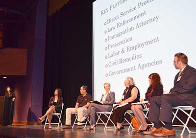 Sharan Dhanoa J.D. '12, standing, moderates SBCEHT panel presentation during the Building Capacity Through Collaboration conference on September 18, 2015, at the Mexican Heritage Plaza, in San Jose.  Left to right:  Santa Clara County Deputy District Attorney Paola Estanislao J.D. '07, SJPD Sgt. Eric Quan, Community Solutions Director Erin O'Brien, Lynette Parker, Ruth Silver Taube and Santa Clara County Sheriff Office Sgt. Kurtis Stenderup.